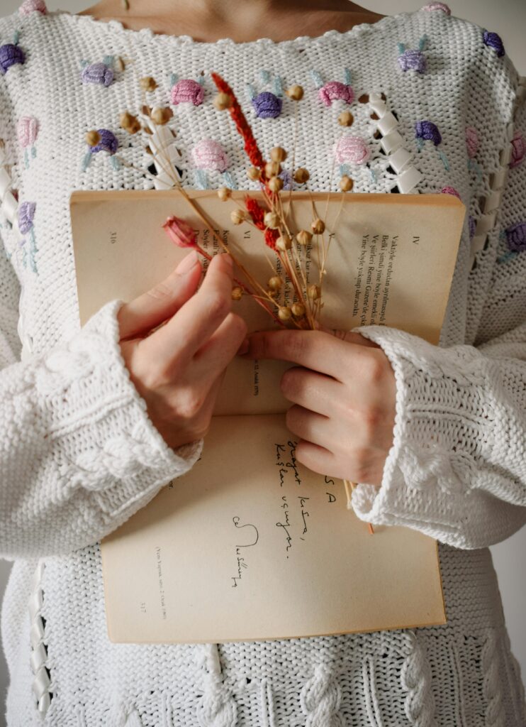 A woman holding an open book with flowers